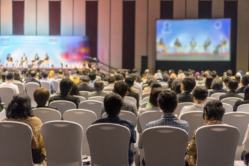 Rear view of Audience listening Speakers on the stage in the conference hall or seminar meeting,...