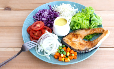 Salmon Salad in Plate on wood floor background, Healthy salad diet food concept, Top view.