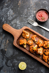 Tandoori Gobi / Roasted cauliflower Tikka is a dry dish made by roasting Cauliflowers in Oven/Tandoor. It's  popular starter food from India. served with ketchup. selective focus