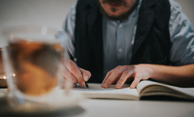 Schriftsteller, Mann schreibt Text auf Papier in ein Buch