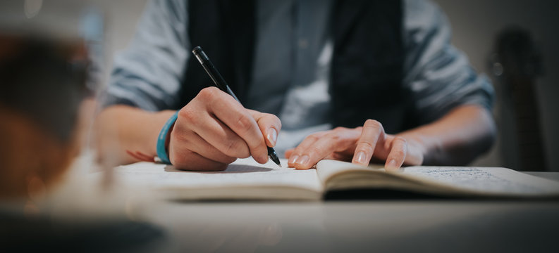 Schriftsteller, Mann schreibt Text auf Papier in ein Buch