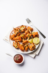 Tandoori Gobi / Roasted cauliflower Tikka is a dry dish made by roasting Cauliflowers in Oven/Tandoor. It's  popular starter food from India. served with ketchup. selective focus