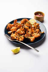 Tandoori Gobi / Roasted cauliflower Tikka is a dry dish made by roasting Cauliflowers in Oven/Tandoor. It's  popular starter food from India. served with ketchup. selective focus