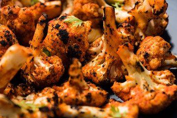 Tandoori Gobi / Roasted cauliflower Tikka is a dry dish made by roasting Cauliflowers in Oven/Tandoor. It's  popular starter food from India. served with ketchup. selective focus