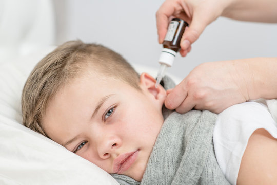 Close Up Doctor Drips Medicine Into The Ear Of A Sick Boy