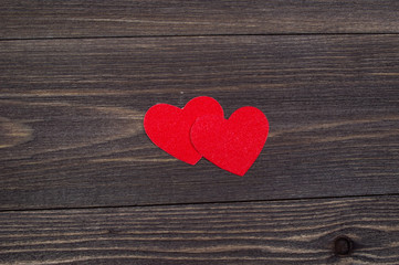 Two paper hearts on a wooden table on Valentine's Day