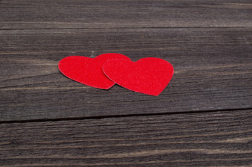 Fototapeta premium Two paper hearts on a wooden table on Valentine's Day