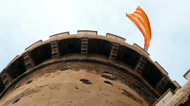 Spanish flag waving on the Torres de Quart, gateway to the medieval Christian wall of Valencia