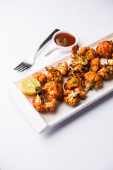 Tandoori Gobi / Roasted cauliflower Tikka is a dry dish made by roasting Cauliflowers in Oven/Tandoor. It's  popular starter food from India. served with ketchup. selective focus