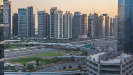 Aerial view to JLT and Dubai Marina with big highway intersection timelapse on sheikh zayed road and skyscrapers in the distance.