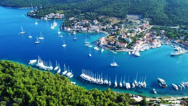 Aerial video from iconic traditional fishing village and bay of Fiskardo with beautiful houses and Ionian architecture, Cefalonia island, Greece