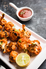 Tandoori Gobi / Roasted cauliflower Tikka is a dry dish made by roasting Cauliflowers in Oven/Tandoor. It's  popular starter food from India. served with ketchup. selective focus