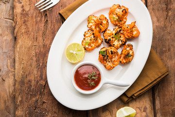 Tandoori Gobi / Roasted cauliflower Tikka is a dry dish made by roasting Cauliflowers in Oven/Tandoor. It's  popular starter food from India. served with ketchup. selective focus