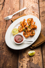 Tandoori Gobi / Roasted cauliflower Tikka is a dry dish made by roasting Cauliflowers in Oven/Tandoor. It's  popular starter food from India. served with ketchup. selective focus