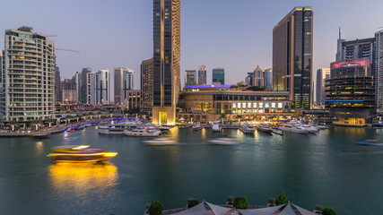 Aerial vew of Dubai Marina with shoping mall, restaurants, towers and yachts day to night timelapse, United Arab Emirates.