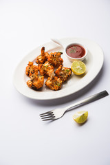 Tandoori Gobi / Roasted cauliflower Tikka is a dry dish made by roasting Cauliflowers in Oven/Tandoor. It's  popular starter food from India. served with ketchup. selective focus