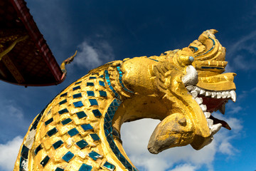 Orange gold dragon statue closeup image in blue sky background in Luang Prabang Laos