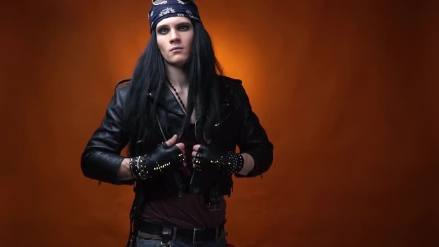 Edgy rocker wearing makeup and bandana, adjusting his leather jacket