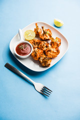 Tandoori Gobi / Roasted cauliflower Tikka is a dry dish made by roasting Cauliflowers in Oven/Tandoor. It's  popular starter food from India. served with ketchup. selective focus