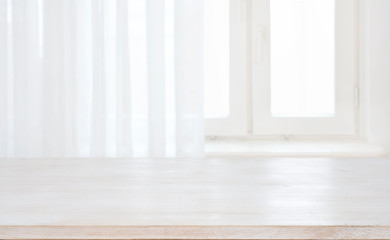 Wood table top on defocused pastel background of curtained window