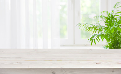 Wood table top on blurred background of window with curtain