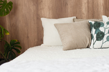 beige pillown on comfortable bed in modern bedroom interior.