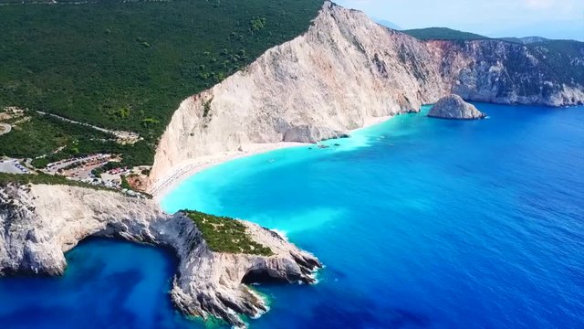 Aerial drone video of popular tropical paradise deep turquoise beach of Porto Katsiki with white steep rocky seascape and beautiful cloudy landscape, Lefkada island, Ionian, Greece