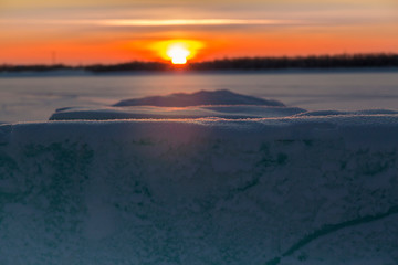 January sunset over a snow covered river