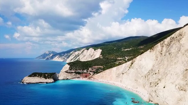 Aerial drone video of popular tropical paradise deep turquoise beach of Porto Katsiki with white steep rocky seascape and beautiful cloudy landscape, Lefkada island, Ionian, Greece