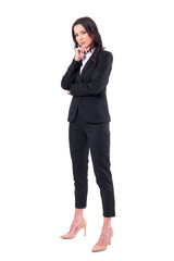 Confident successful business woman in black formal suit standing and looking at camera. Full body isolated on white background. 