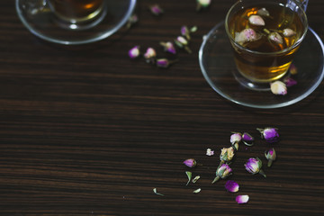 Obraz na płótnie Canvas Rose oriental tea in transparent glass cups on dark wood background.