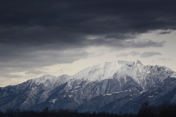 Fototapeta na wymiar Snow-capped Mountain with Overcast Clouds in Switzerland.