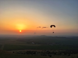 silhouette of paraglider at sunset