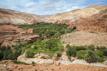 Fototapeta na wymiar Green oasis in an arid desert landscape with old Berber villages in the surrounding valley of the Atlas Mountains in Morocco, near Ouarzazate