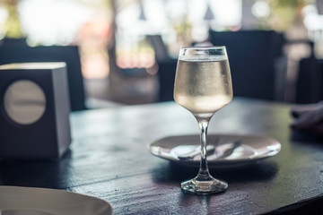 a glass of white wine on a table in restaurant