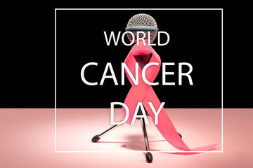 The text world cancer day and a pink ribbon with microphone on a pink background. The cancer, health, breast, awareness, campaign, disease, help, care, support, hope, illness, survivor and healthcare