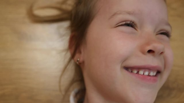 Top view happy smiling face portrait little child girl lies playing with guinea pig pet at home