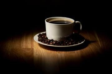 cup of coffee with beans on black background