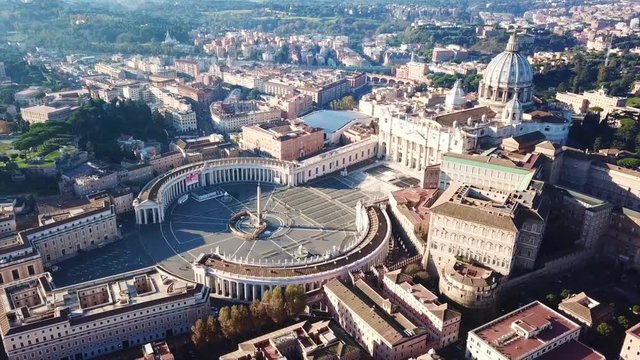 Aerial drone video of Saint Peter's square in front of world's largest church - Papal Basilica of St. Peter's, Vatican - an elliptical esplanade created in the mid seventeenth century, Rome, Italy