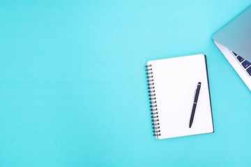 Flat lay,Top view office table desk. Workspace with notebook, black pen , laptop on the indigo blue background.Copy Space for text,Empty Blank to word.Business Finance,Education Technology Concept.