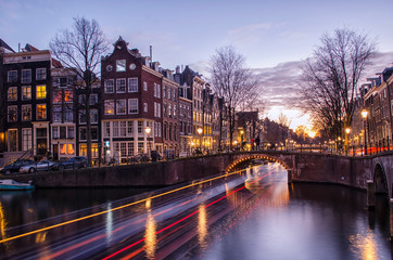 Fototapeta na wymiar Light Trails in Amsterdam Canal at Sunset