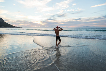 Senior man preparing to swim in the sea at dawn