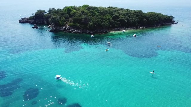 Aerial drone bird's eye view video of famous sandy beach and small island of Agia Paraskevi with emerald clear sea, Sivota, Thesprotia, Epirus, Greece