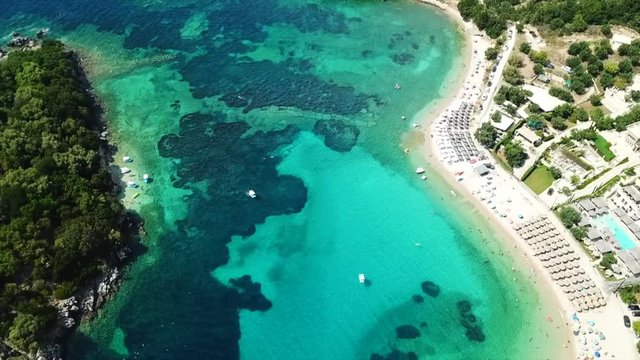 Aerial drone bird's eye view video of famous sandy beach and small island of Agia Paraskevi with emerald clear sea, Sivota, Thesprotia, Epirus, Greece