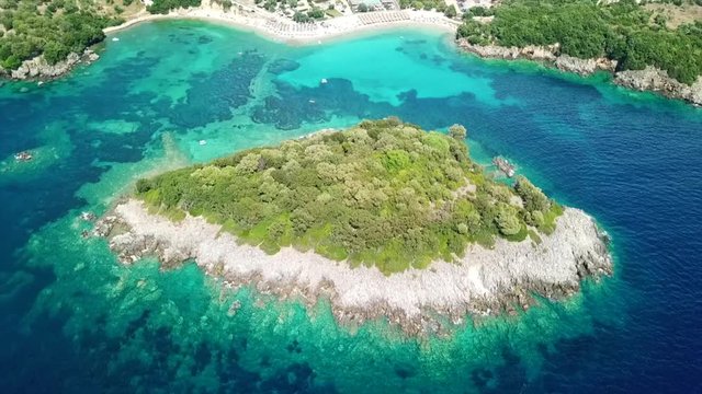 Aerial drone bird's eye view video of famous sandy beach and small island of Agia Paraskevi with emerald clear sea, Sivota, Thesprotia, Epirus, Greece