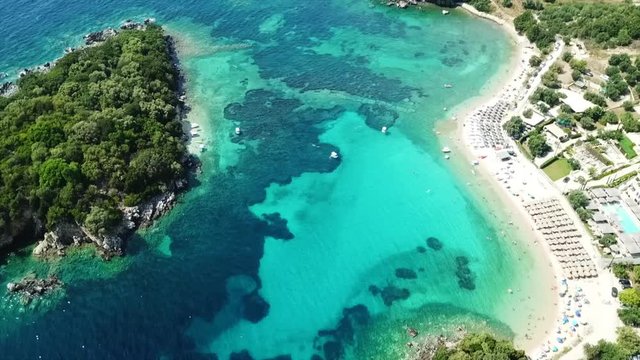 Aerial drone bird's eye view video of famous sandy beach and small island of Agia Paraskevi with emerald clear sea, Sivota, Thesprotia, Epirus, Greece