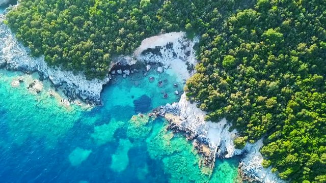 Aerial drone bird's eye view video of famous sandy beach and small island of Agia Paraskevi with emerald clear sea, Sivota, Thesprotia, Epirus, Greece