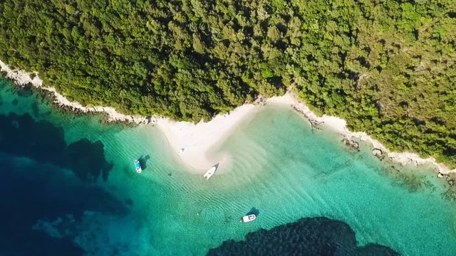 Aerial drone bird's eye view video of famous sandy beach and small island of Agia Paraskevi with emerald clear sea, Sivota, Thesprotia, Epirus, Greece
