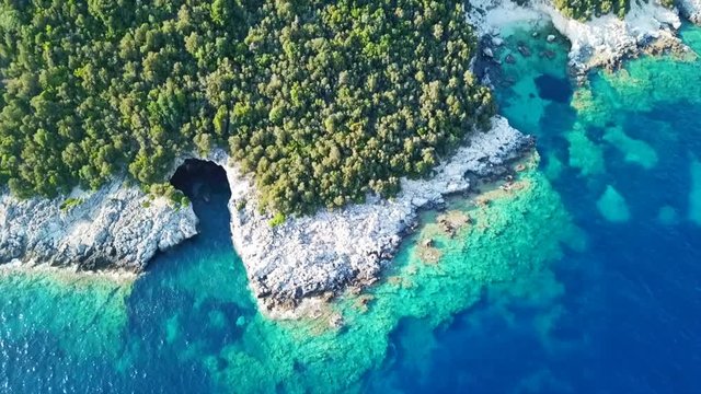 Aerial drone bird's eye view video of famous sandy beach and small island of Agia Paraskevi with emerald clear sea, Sivota, Thesprotia, Epirus, Greece