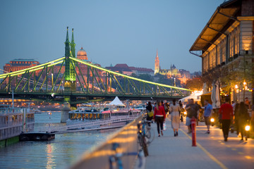 Waterfront promenade in Budapest by night, Liberty bridge, walking people